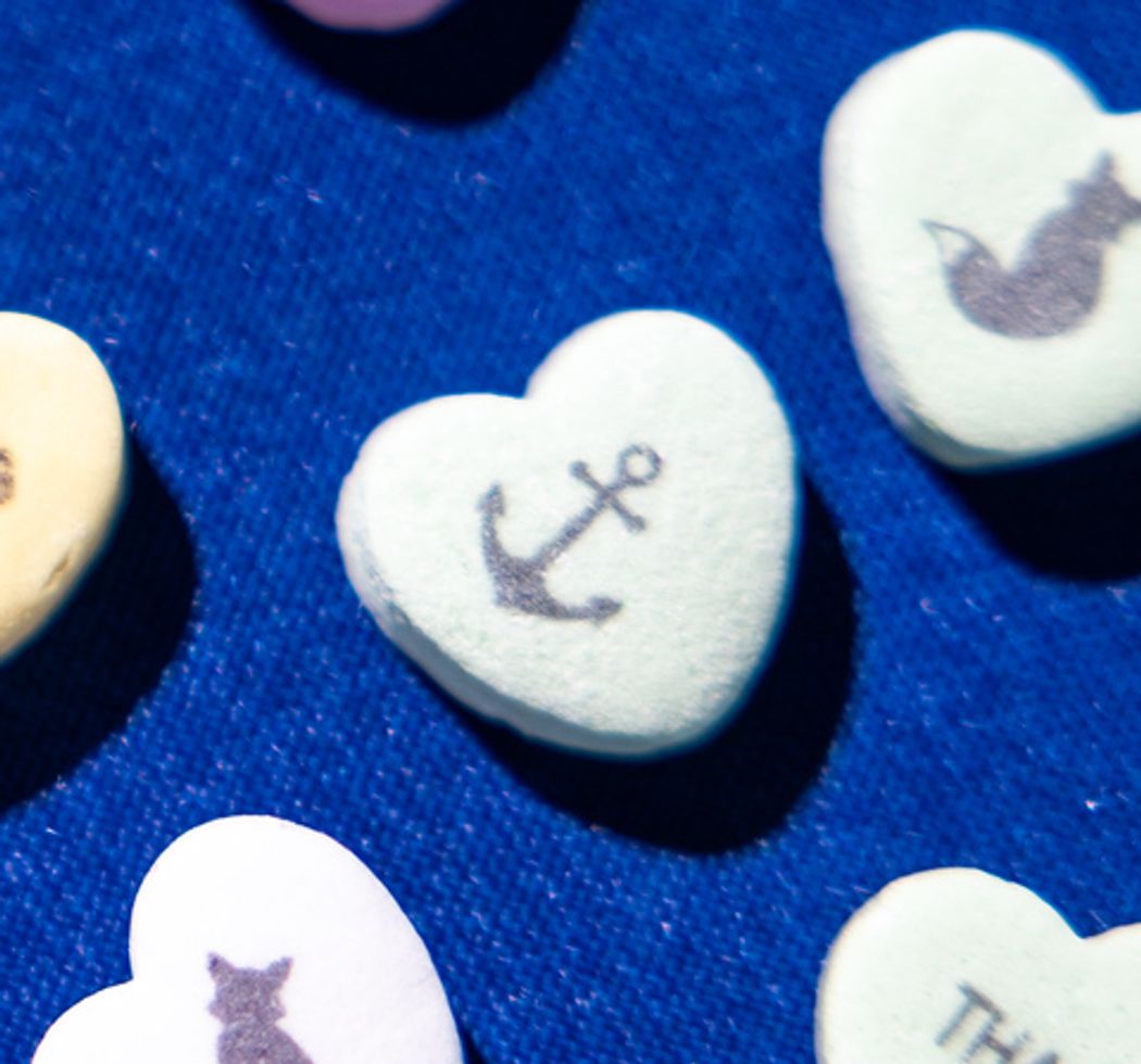 Green candy heart with an anchor silhouette on it. 