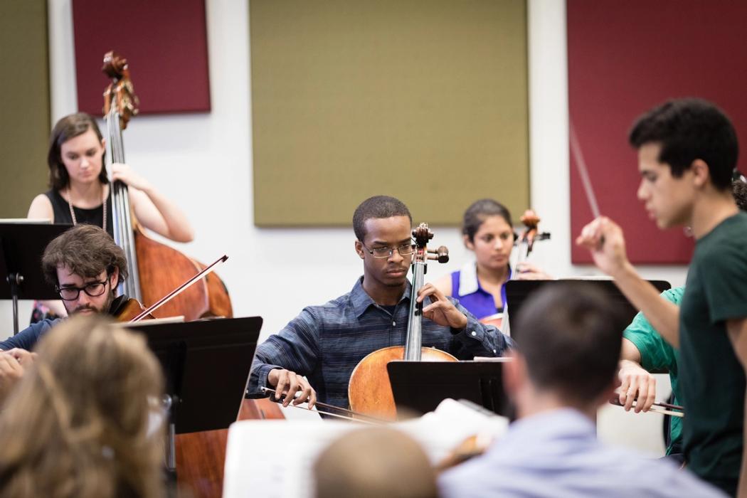 Rollins students practice a piece of music together.