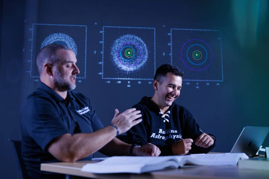 Rollins astrophysics professor, Chris Fuse, talks with a student. 