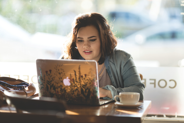 Student asking questions on a laptop in a coffee shop