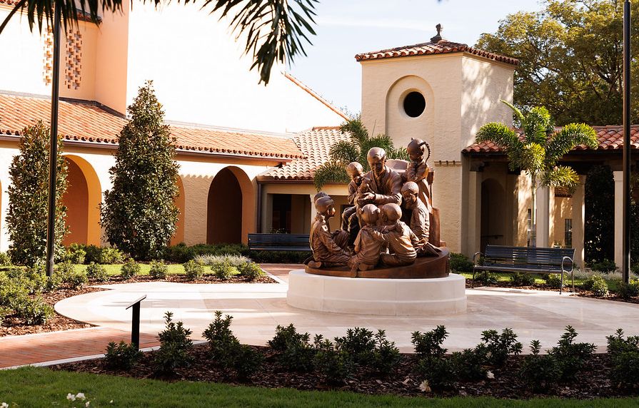 Orange writing on a black chalkboard that says it's always a beautiful day in the neighborhood at Rollins.