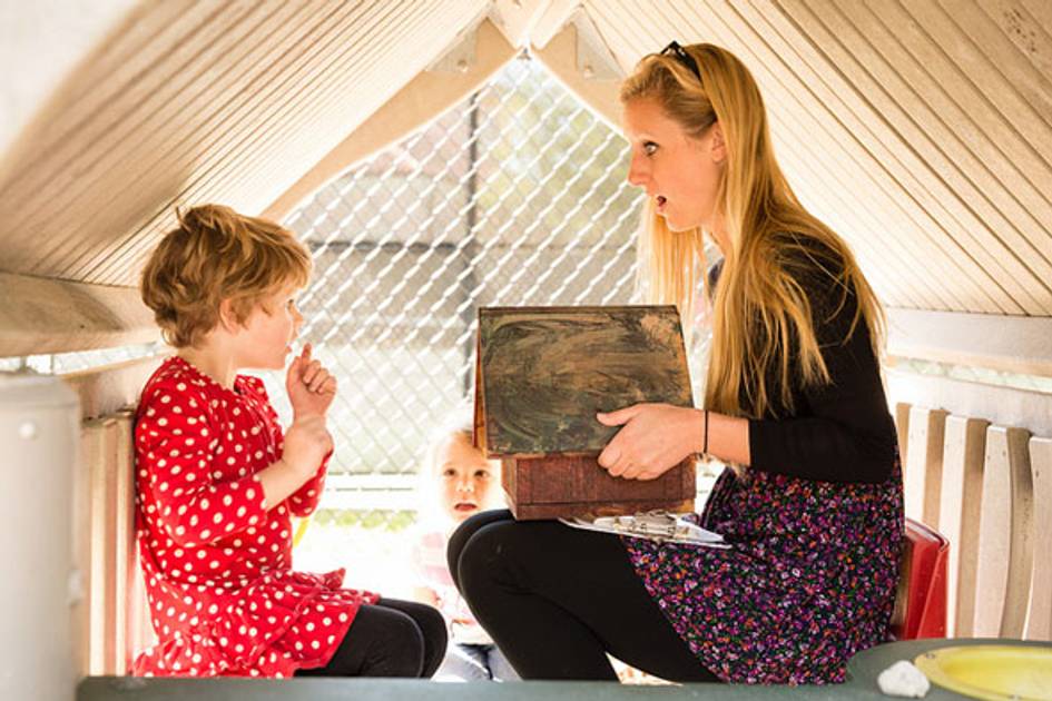 Rollins student and pre-school child play in a fort together.