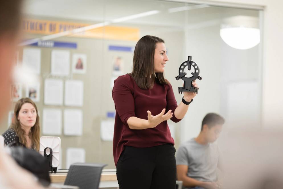 Physics professor Whitney Coyle explains how to use a lens holder for an optics lab.