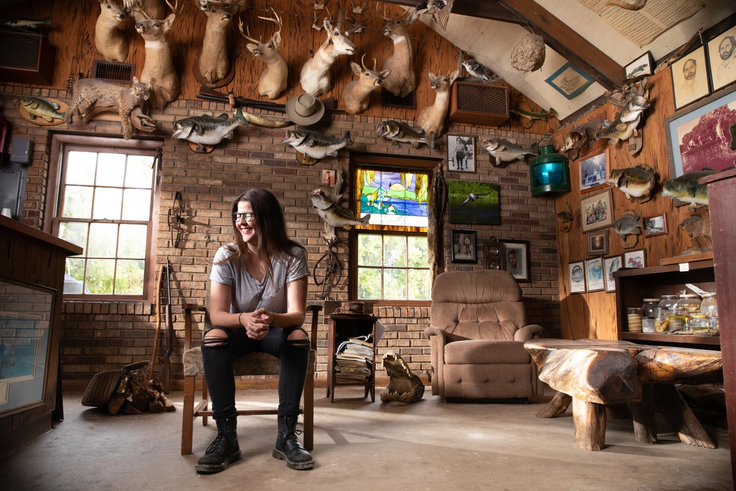 Best-selling author Kristen Arnett ’12 pictured in a lodge adorned with taxidermy.