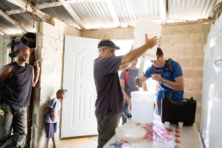 A chemistry professor and student install a water filtration system in a home in the Dominican Republic.