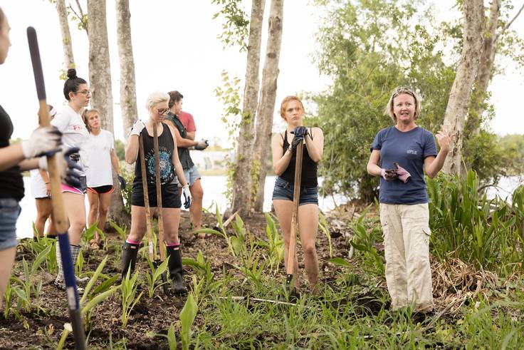 Rollins student and a professor are conducting fieldwork with shovels