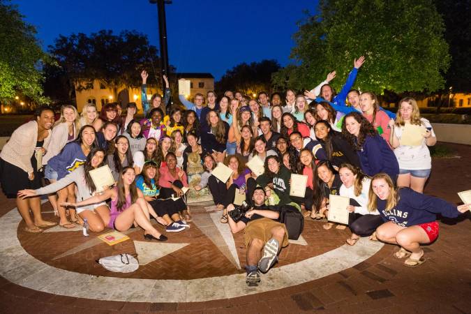 A large group of students pose with the fox statue on Tars Plaza.