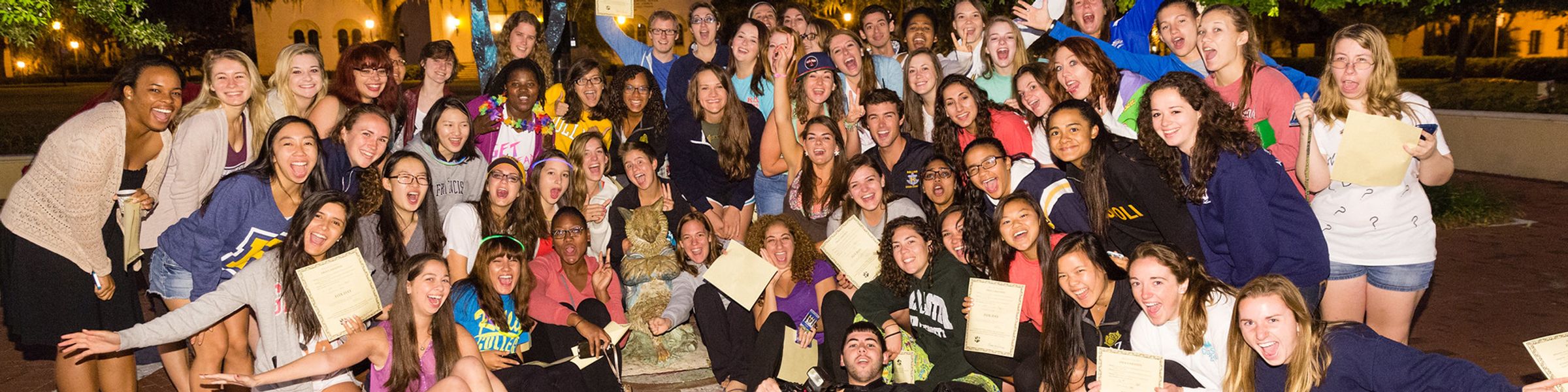 Group of students surround the fox statue on Tars Plaza in the early morning hours of Fox Day.