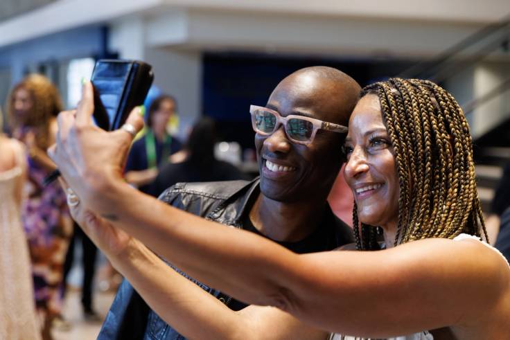 Two people smiling and taking a selfie with iPhone.