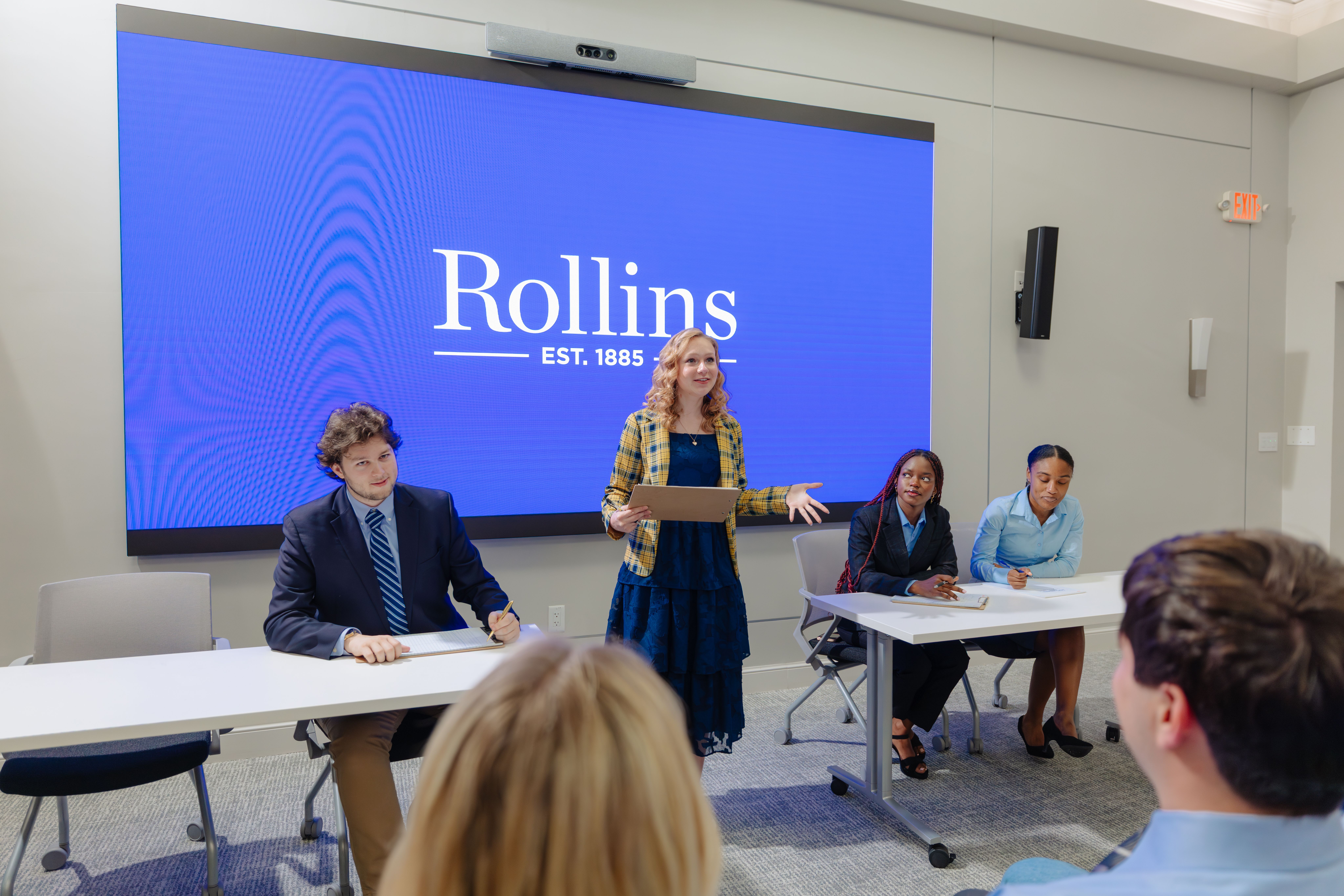 Debate student leads a tournament before a Rollins display.