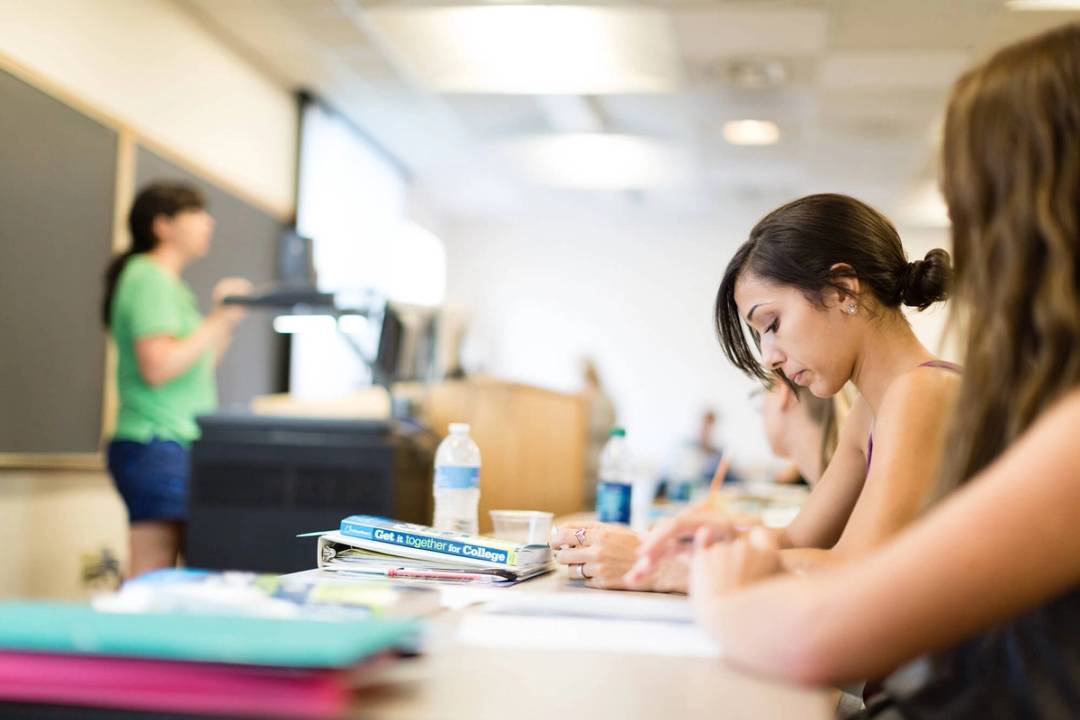 A student takes notes during a college prep class.