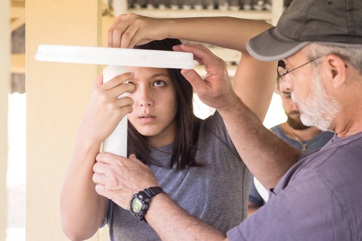 A student and professor work on assembling water filters to install across the Dominican Republic.