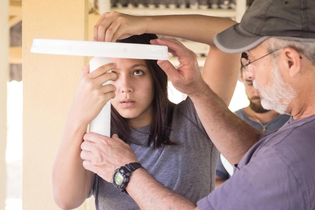 A student and professor work on assembling water filters to install across the Dominican Republic.