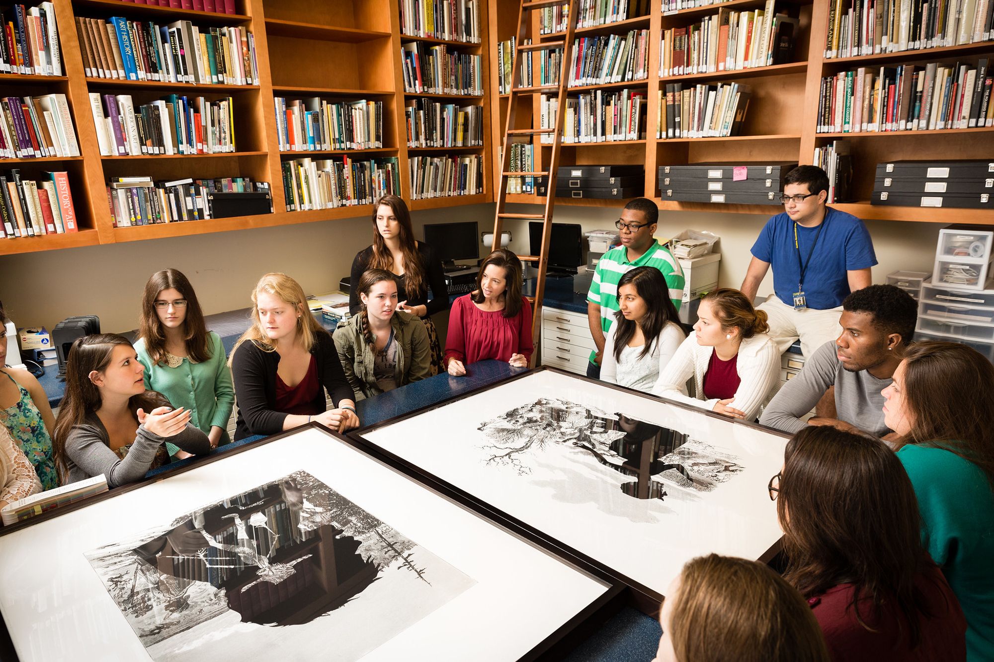 A group of students discuss a pair of artworks.