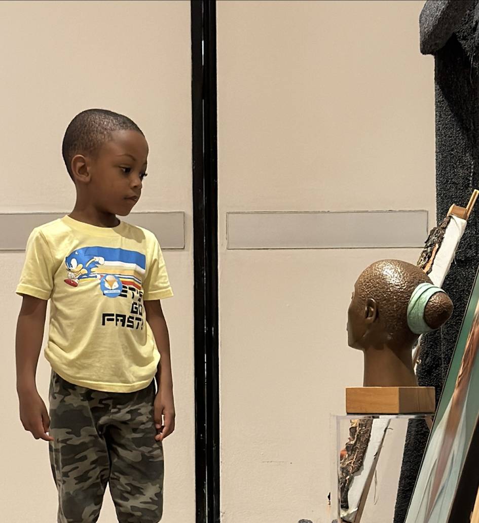 A five-year-old child chooses his favorite artwork among a selection of works from the RMA collection. Photo courtesy of the Hume House Child Development & Student Research Center