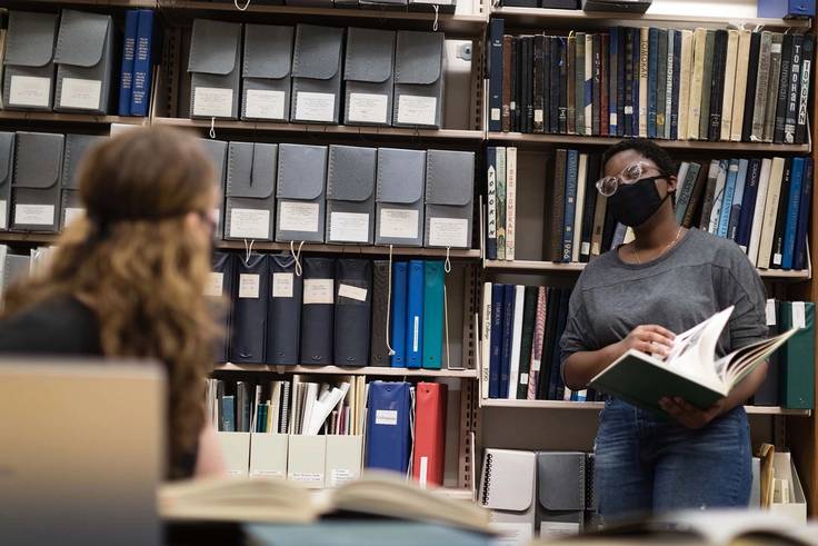 Students conduct research in the Olin Library stacks. 