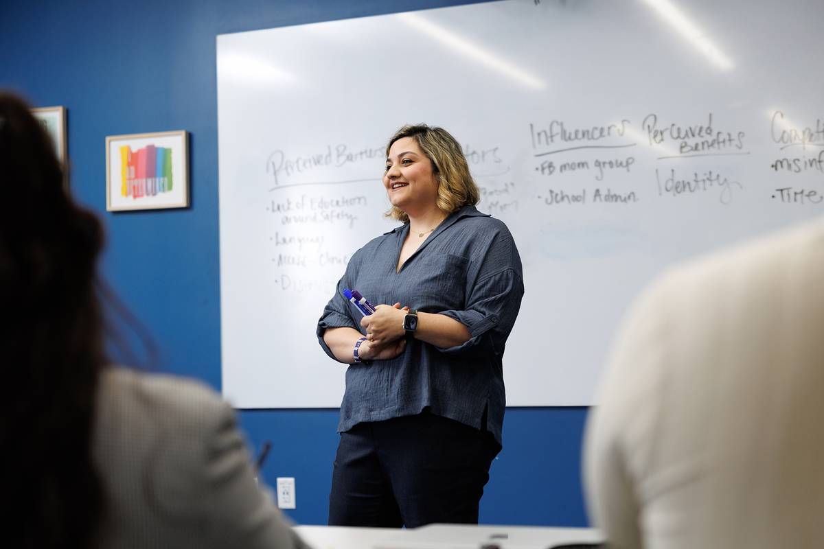Professor leading a discussion in front of a whiteboard during workshop