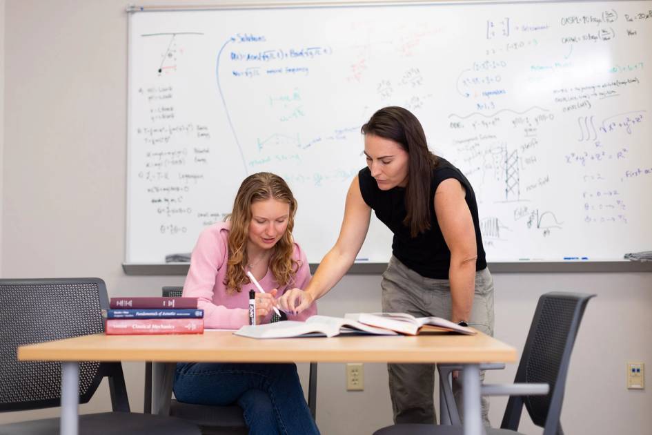 A physics student works one on one with a professor.