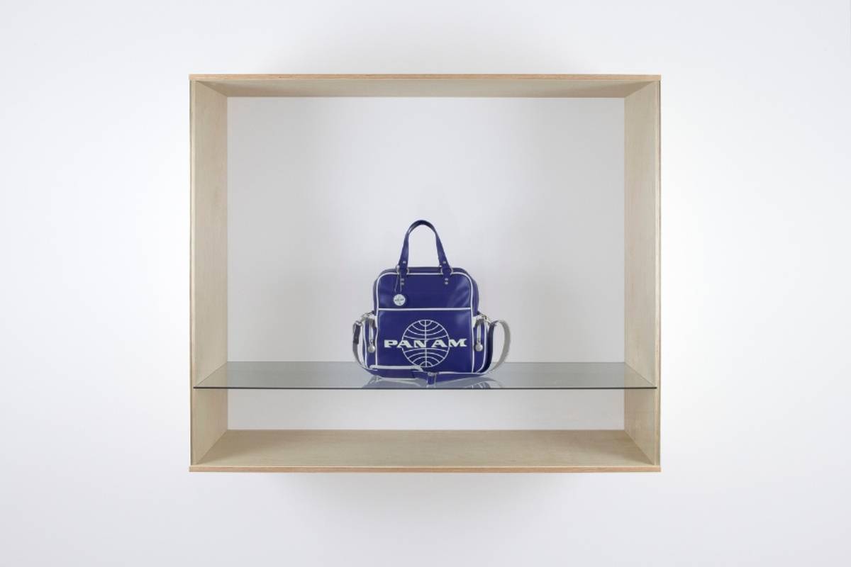 Blue Pan Am travel bag displayed inside a wooden case