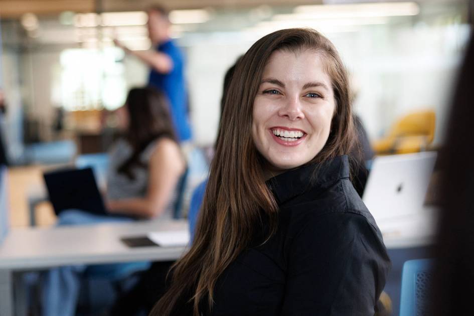 A student smiles at a classmate during a strategic communications class at Rollins.