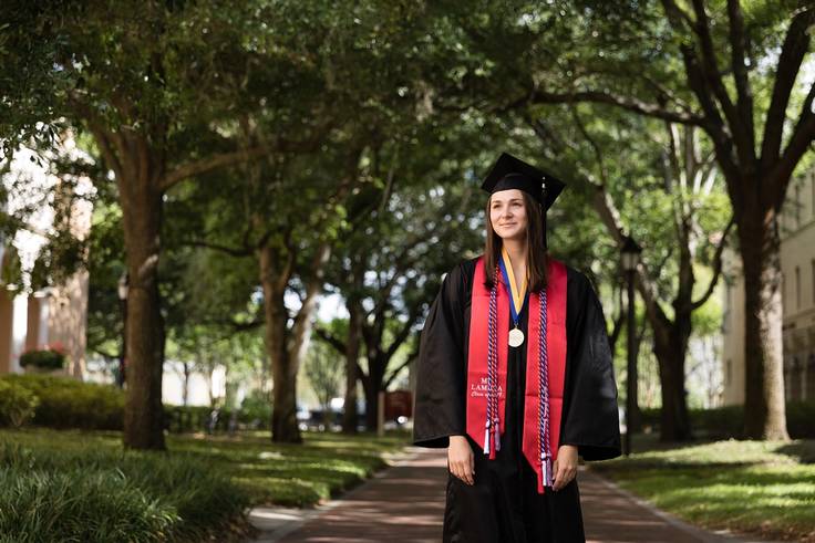 A valedictorian poses on the Rollins College campus.