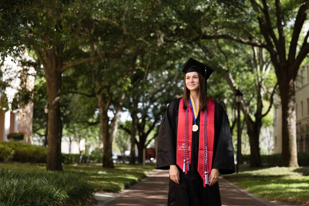 A valedictorian poses on the Rollins College campus.