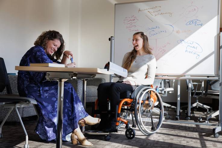 Elizabeth Smith ’22 ’24MPH sits in her wheelchair with Professor Parsloe working on accessibility rights research