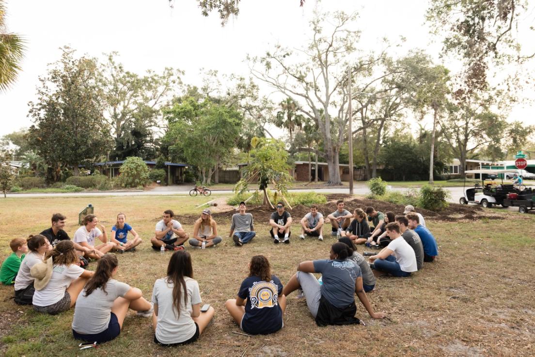 Students sit in a large circle.