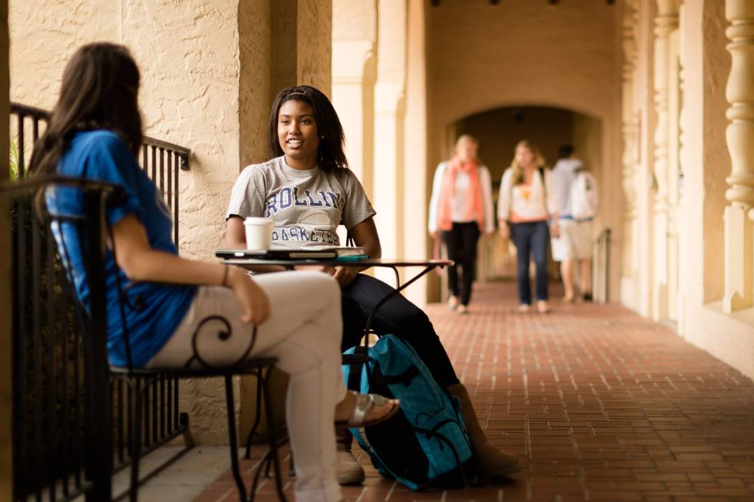 A student chats with a Rollins staff member over coffee.