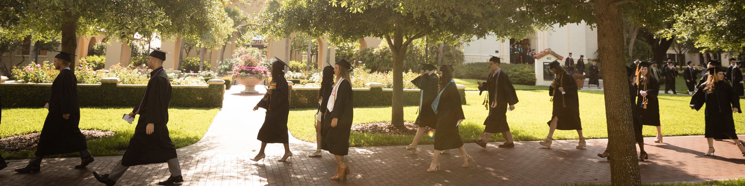 Graduates waking through campus during graduation event.