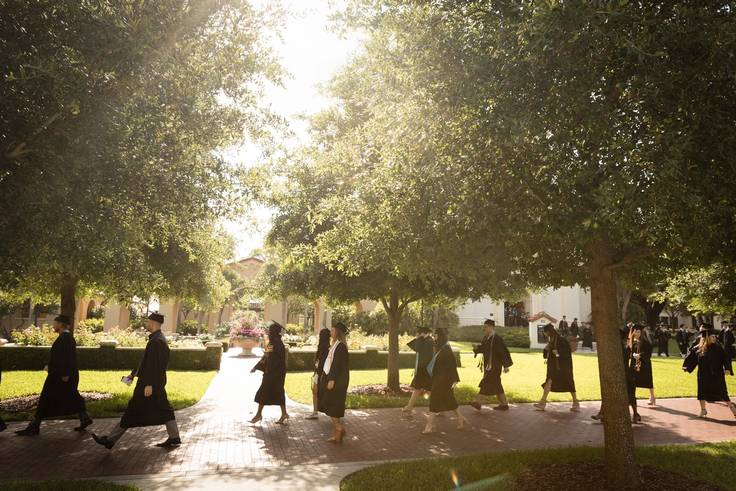 Students walk past the rose garden on commencement day.