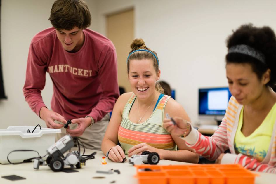 A group of Rollins College students build a robot in class. 