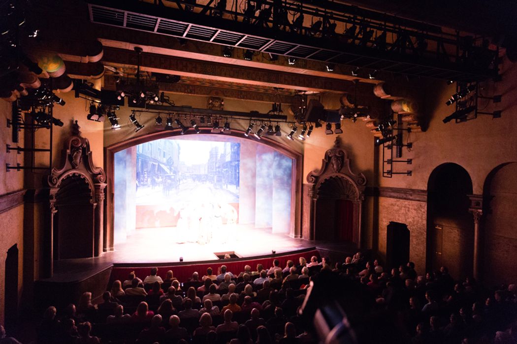 Interior of the Annie Russell Theatre, bright stage and full audience