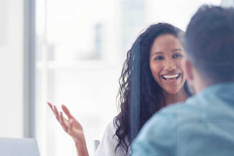 Smiling professional engaged in friendly conversation during an office meeting