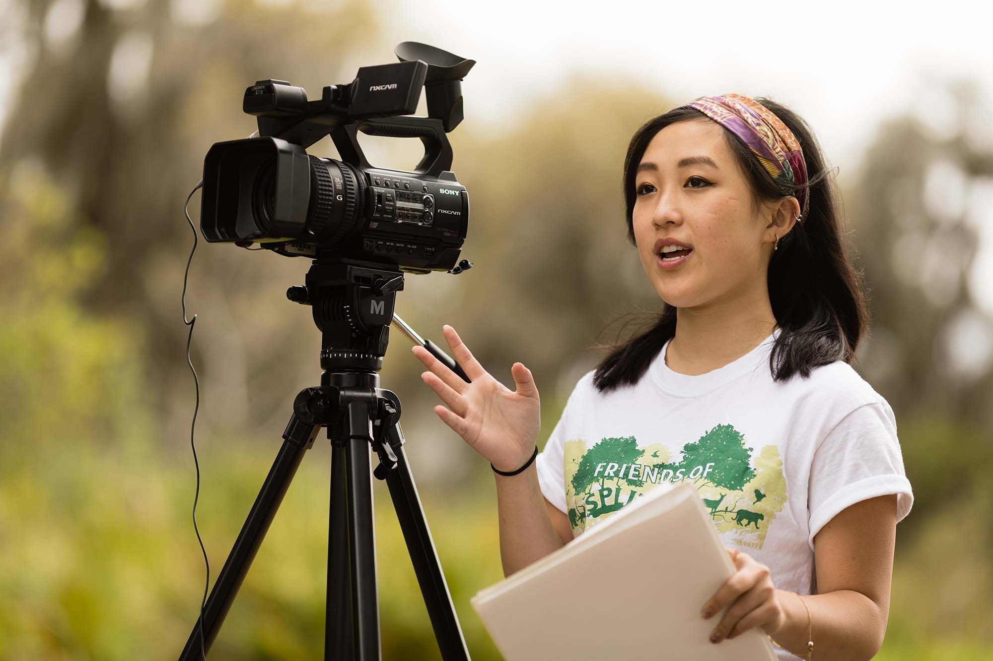 Rollins student directing from behind a camera