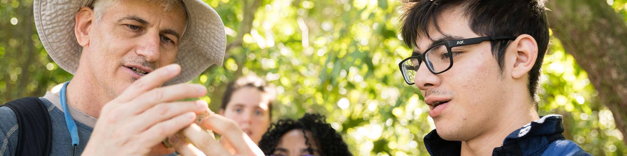 Rollins environmental studies professor holds up an item found on a hike to students for discussion.