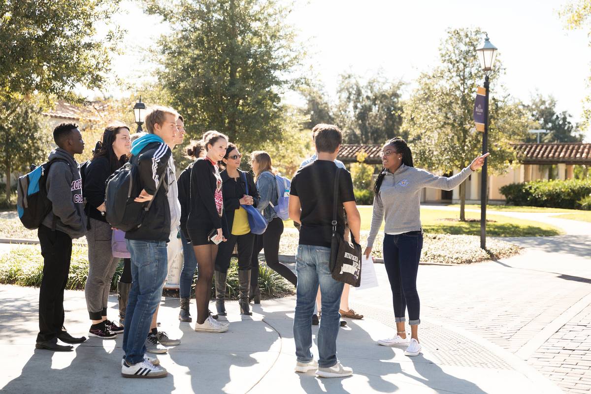 A student tour guide leads a large group tour at Rollins.