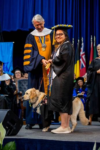 Cecilia Hernandez '25 with service dog Canela at Commencement