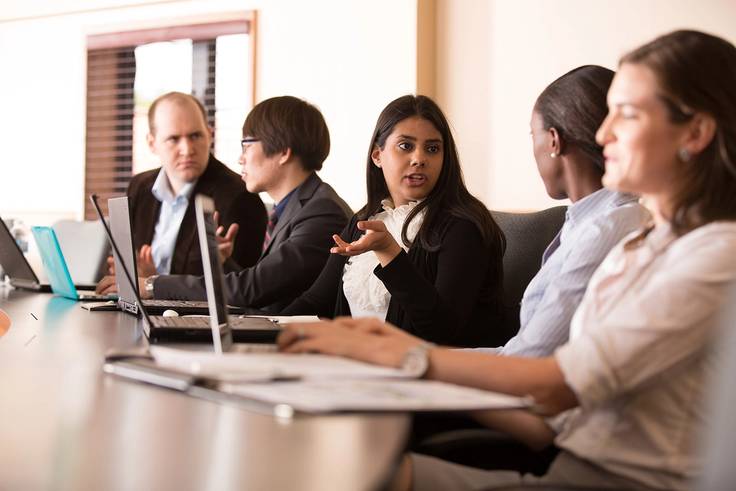 Rollins masters students in a meeting.