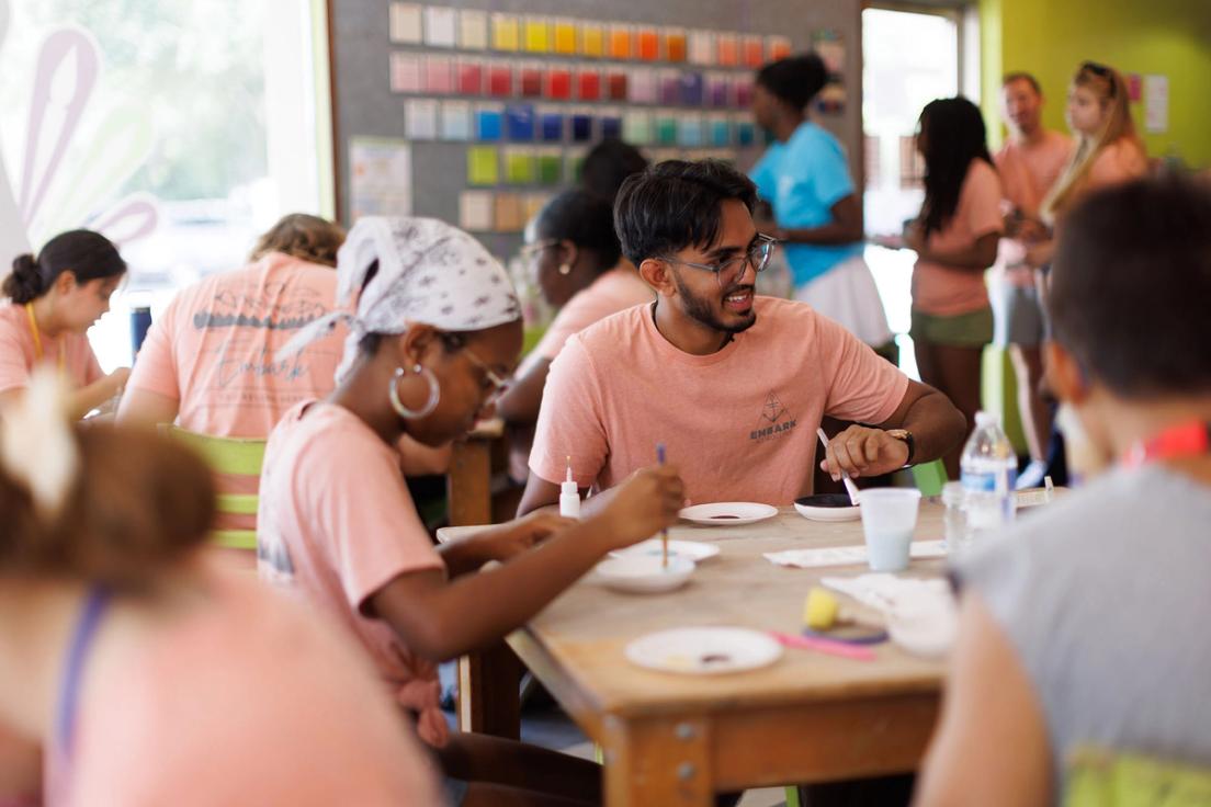 Students painting pottery as part of an EMBARK orientation event.