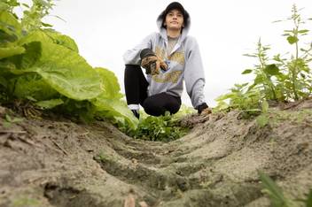 Student kneeling in the dirt on an Immersion experience focused on the lives of migrant farmworkers.