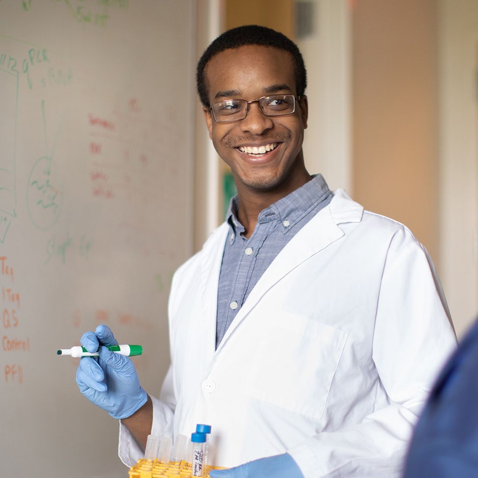 Brandon McNichol writing on dry erase board in classroom