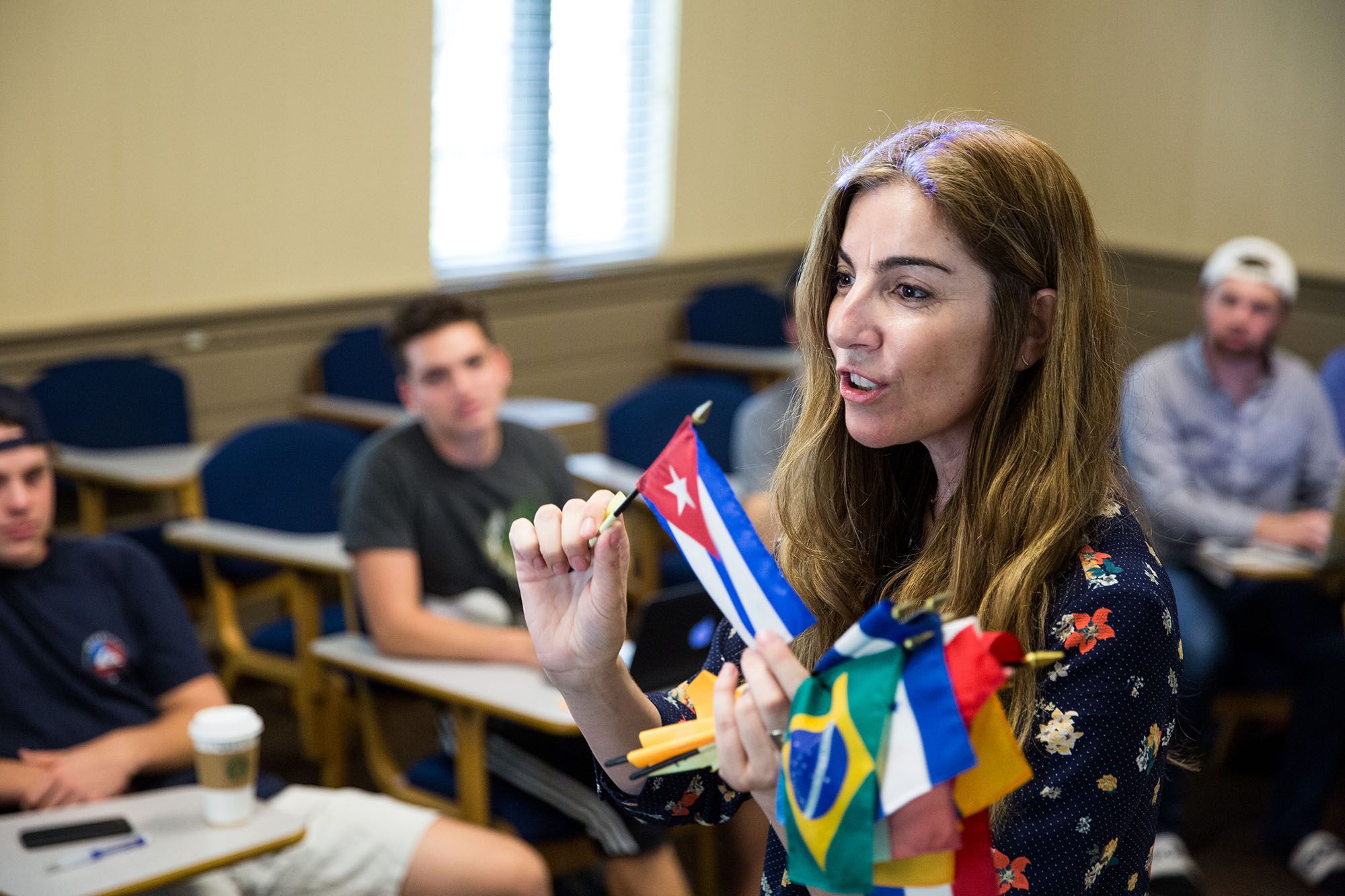 Hispanic studies professor showing examples of international flags to students.