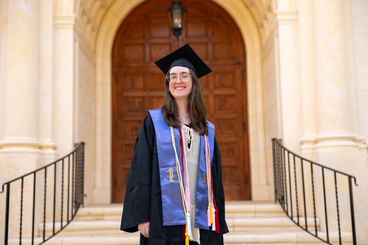 Delaney Benton in graduation regalia on Rollins campus. 