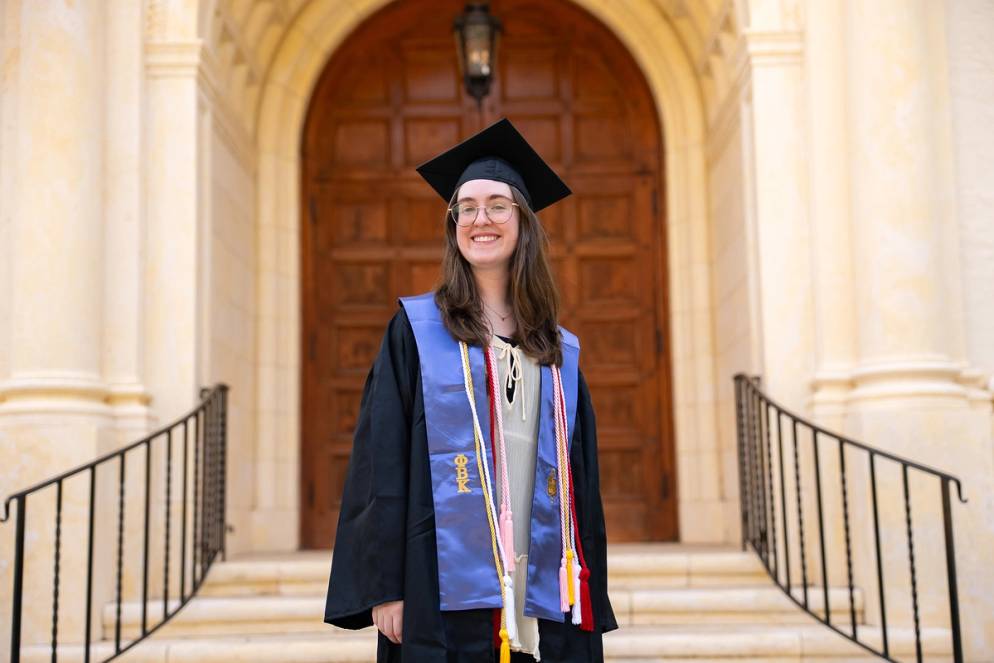 Delaney Benton in graduation regalia on Rollins campus.