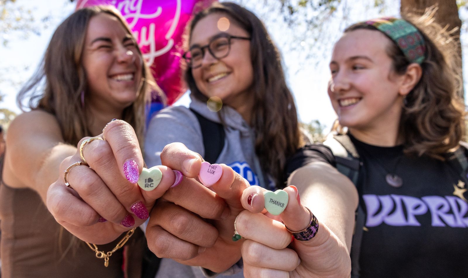 Three female students holding candy hearts.