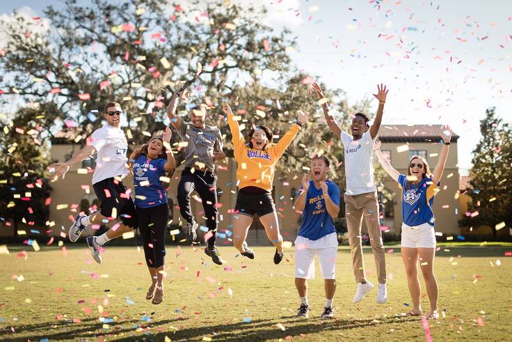 Students celebrate on campus with confetti.
