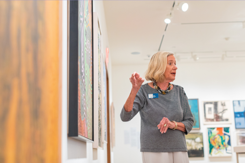 Woman points to painting in art gallery