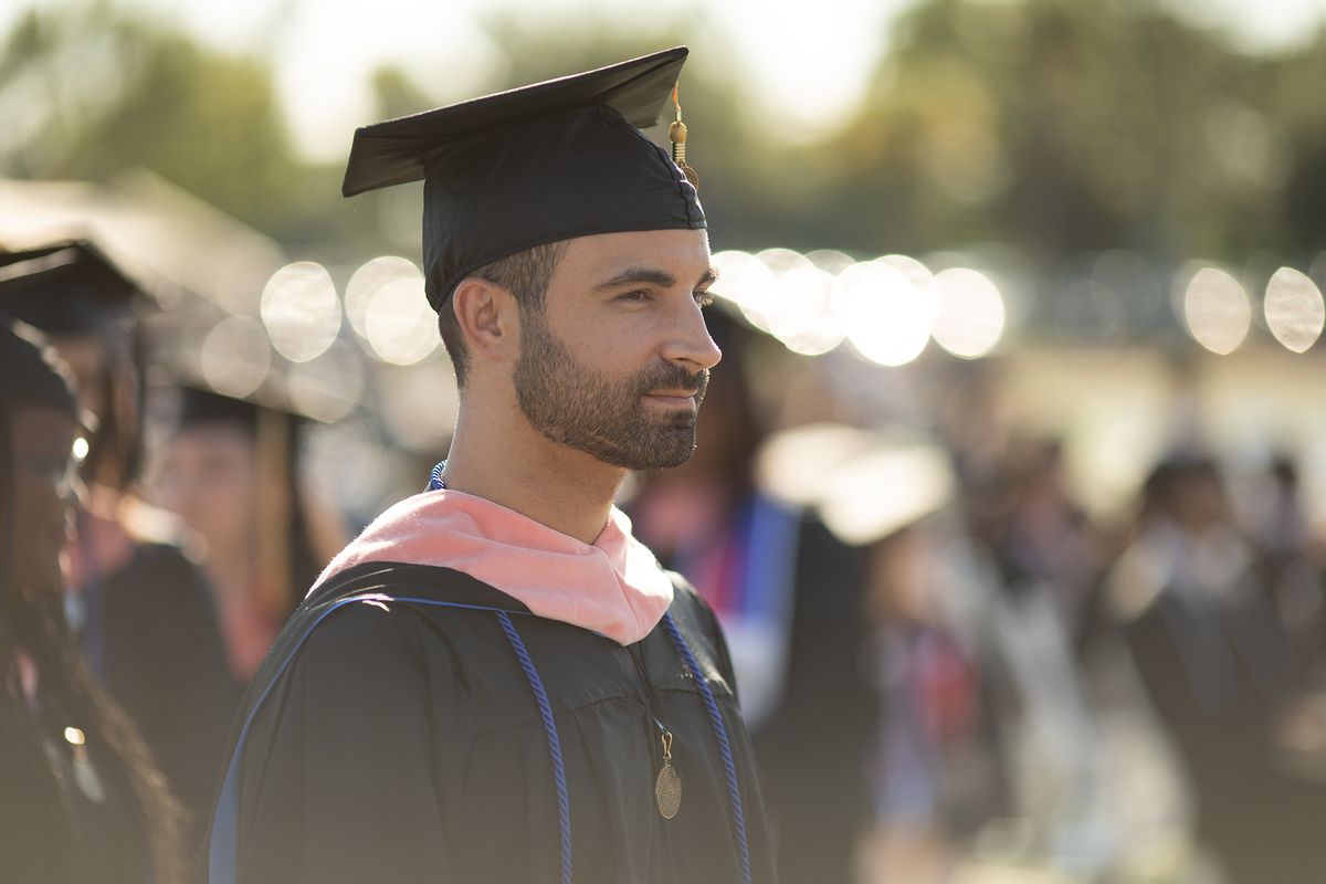 An adult college graduate at his commencement ceremony. 