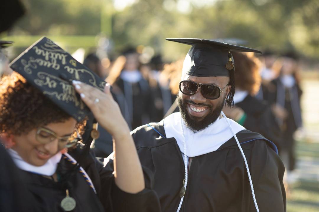 Rollins College student poses with their diploma at commencement.